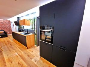 MuntzenheimにあるLOFT & SPA-6 Pers-Jacuzzi-Parking-Jardin-Clim-Colmarのキッチン(黒いキャビネット付)