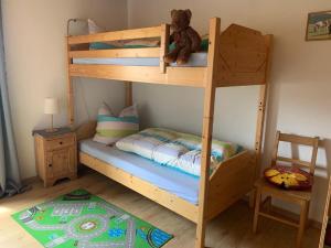 a wooden bunk bed with a teddy bear sitting on top at Mattheishof in Grafenau