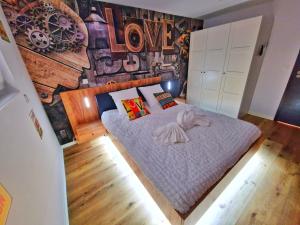 MuntzenheimにあるLOFT & SPA-6 Pers-Jacuzzi-Parking-Jardin-Clim-Colmarの大きなベッドとラブウォールのある寝室