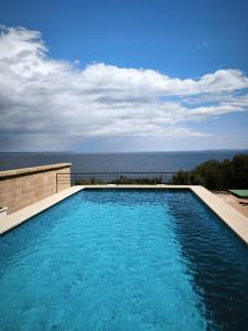 a swimming pool with the ocean in the background at Cas Forner in Cala Pi