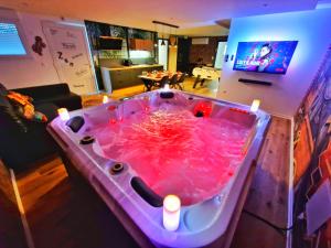 MuntzenheimにあるLOFT & SPA-6 Pers-Jacuzzi-Parking-Jardin-Clim-Colmarのリビングルームにあるキャンドルのついた大きなピンクのバスタブ