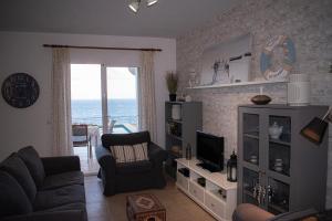 a living room with a couch and a television at Cas Forner in Cala Pi