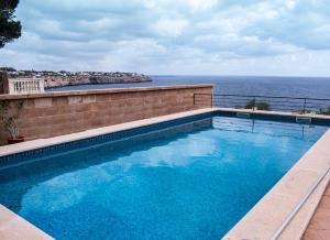 a swimming pool with a view of the ocean at Cas Forner in Cala Pi