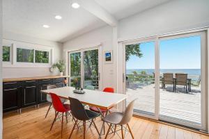 een keuken met een tafel en stoelen en uitzicht op de oceaan bij Private Beachfront Lake Michigan Getaway in West Olive