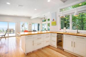 een keuken met witte kasten en ramen en een tafel bij Private Beachfront Lake Michigan Getaway in West Olive