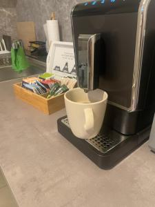 a coffee maker with a cup sitting on a counter at Little Royal in Garbsen +15 photos