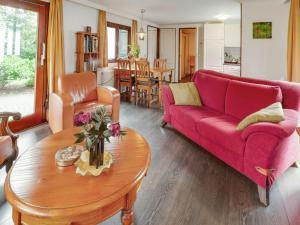 a living room with a red couch and a table at Chalet in Stegeren with Pool and Gardens in Stegeren