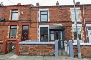 a brick building with a gate in front of it at Modern & Convenient 2 Bedroom House in St Helens in Saint Helens