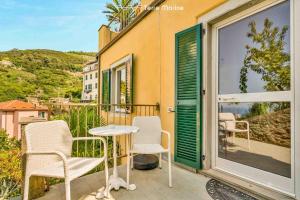 a patio with two chairs and a table on a balcony at Le Onde di Rio, TerreMarine in Riomaggiore