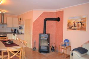 sala de estar con estufa de leña en la cocina en Ferienhaus Albatros, en Ostseebad Karlshagen 16 fotos más