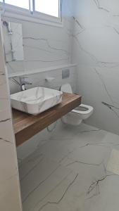 a bathroom with a sink and a toilet at Villa Ayem avec piscine à l'étage in Al Ḩārah al Kabīrah +7 photos