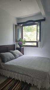 a bedroom with a bed and a window at Casa Rural La Chaparra - Apartamento Atalbéitar in Pitres