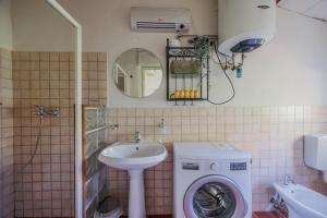 a bathroom with a washing machine and a sink at Appartamento con piscina e giardino - Lavanda in Ghizzano +27 photos