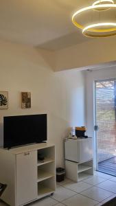 a living room with a flat screen tv on a wall at Charme do Dido in Ilha de Boipeba