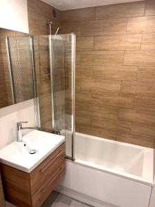 un bagno con vasca, lavandino e doccia di Apartament PREMIUM Agashi - bardzo blisko Atlas Arena, Orientarium i ZOO, Aquapark Fala, Lotnisko Airport a Łódź Altre 5 foto