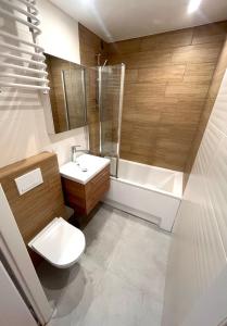 un bagno con un water, un lavandino e una vasca di Apartament PREMIUM Agashi - bardzo blisko Atlas Arena, Orientarium i ZOO, Aquapark Fala, Lotnisko Airport a Łódź