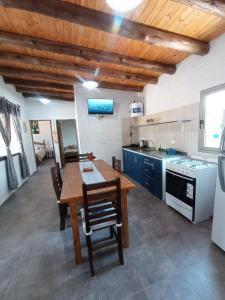 a kitchen with a wooden table and a kitchen with blue cabinets at Cabañas Universo in San Rafael