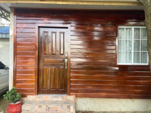 a wooden house with a door and a window at Grethel apartamento in Omoa