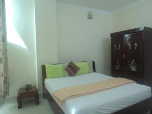 a small bedroom with a bed and a night stand at An Phuc Hotel in Vung Tau