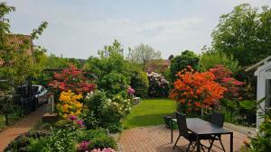 a garden with colorful flowers and a table and chairs at 4 Sterne Ferien Martens in Cuxhaven
