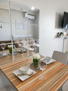 a wooden table with wine glasses and flowers on it at Haven Staycation by Alexa Grace in Lapu Lapu City