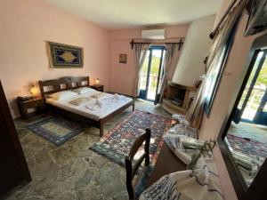a bedroom with a bed and a fireplace at Arolithos Traditional Village Hotel in Tílisos +74 photos