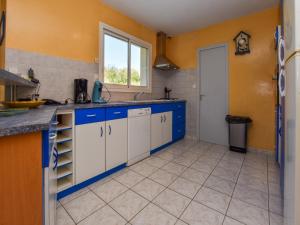 a kitchen with blue and white cabinets and a window at Coastal Retreat in Plurien in Plurien +27 photos