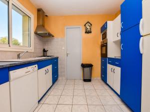 a kitchen with blue and white cabinets and a window at Coastal Retreat in Plurien in Plurien