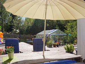 an umbrella on a wooden table with chairs and a gazebo at 8 person holiday home in FAGERFJÄLL RÖNNÄNG in Bräcke +27 photos