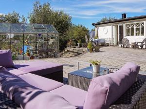 a patio with purple couches and a glass greenhouse at 8 person holiday home in FAGERFJÄLL RÖNNÄNG in Bräcke