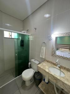 a bathroom with a toilet and a sink and a shower at Pousada Recanto Armação in Penha +9 photos
