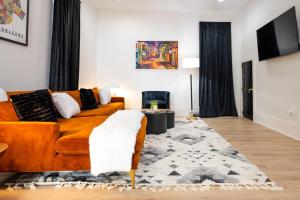 un soggiorno con divano arancione e tappeto di Luxe New Construction Home in Quiet Neighborhood a New Orleans