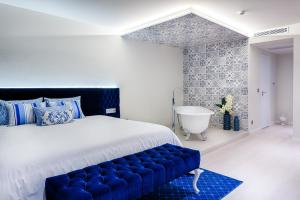 a bedroom with a large bed and a bath tub at Hotel Cristal Porto in Porto