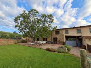 a backyard of a house with a table and a bench at Rural Can Garriga in Palol de Revardit