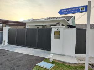 a house with a black and white fence at Homestay 229 Private Pool behind PD Ostrich Farm in Port Dickson