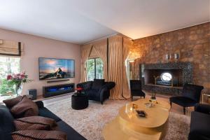 a living room filled with furniture and a fireplace at Exclusive villa with swimming pool in Voula in Athens