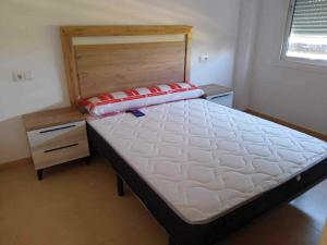 a large bed in a room with a wooden frame at Appartement Las Terrazas De La Torre in Las Pedreñas