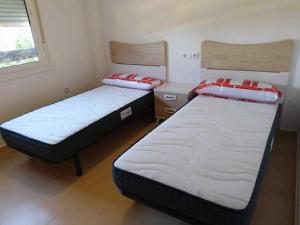 two beds in a small room with at Appartement Las Terrazas De La Torre in Las Pedreñas