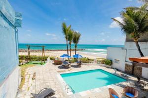 a swimming pool with the beach in the background at Hotel Paraiso Natal - Beira Mar in Natal