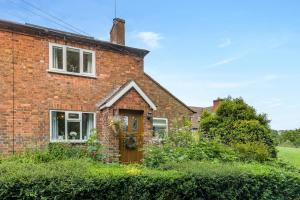 une maison en briques avec une fenêtre et une porte dans l'établissement Southside Cottage, à Neenton