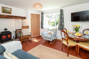 un salon avec une table et une cheminée dans l'établissement Southside Cottage, à Neenton