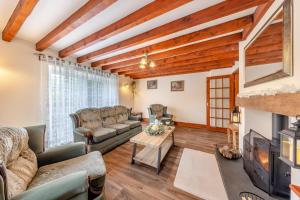 a living room with couches and a fireplace at Stabyl-Y-Ddol in Glyn-Ceiriog