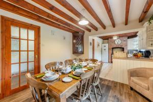 a dining room with a table and chairs and a kitchen at Stabyl-Y-Ddol in Glyn-Ceiriog