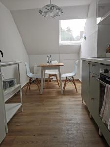 une cuisine avec une table et des chaises dans une pièce dans l'établissement City-Apartment Am Holzberg, à Wilkau-Haßlau