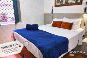 a bedroom with a bed with a blue blanket on it at Hospedaria Rio in Rio de Janeiro