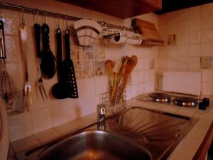a kitchen with a sink and utensils on the wall at Cottage in Vaires-sur-Marne near Forest & Lake in Chelles +22 photos