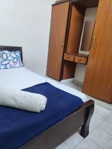 Un dormitorio con una cama y un armario de madera. en Mombasa buxton breeze, en Mombasa