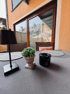 a table with a lamp and a potted plant on it at Da Toni FeWo Chiara in Rüdesheim am Rhein