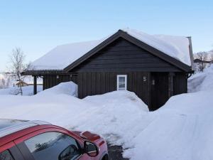 una casa cubierta de nieve con un coche aparcado delante en 10 person holiday home in ÅSERAL, en Åseral 16 fotos más