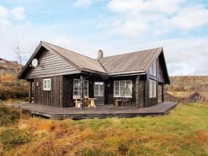 Cabaña pequeña con terraza de madera en un campo en 10 person holiday home in ÅSERAL, en Åseral